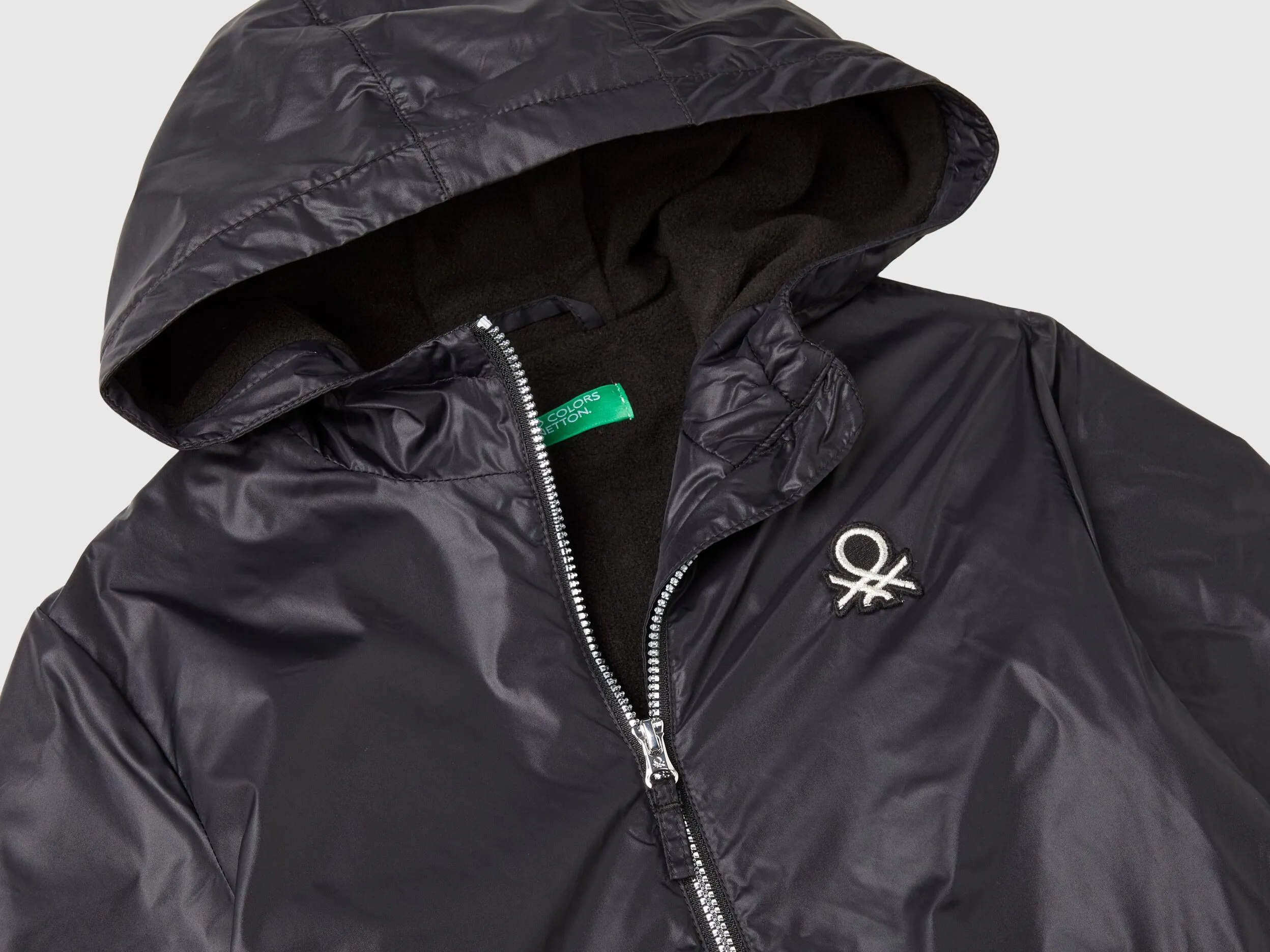 Glossy jacket with zip and hood - Black | Benetton